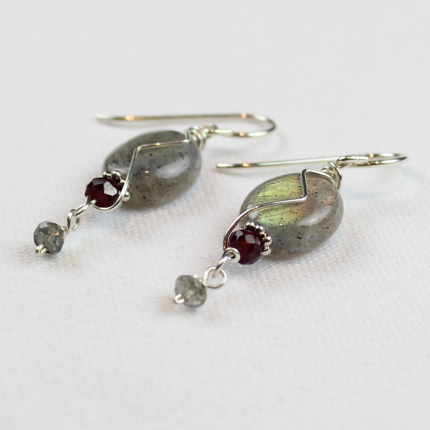 Oval labradorite earrings with garnets and small labradorite dangle. sterling wire accent