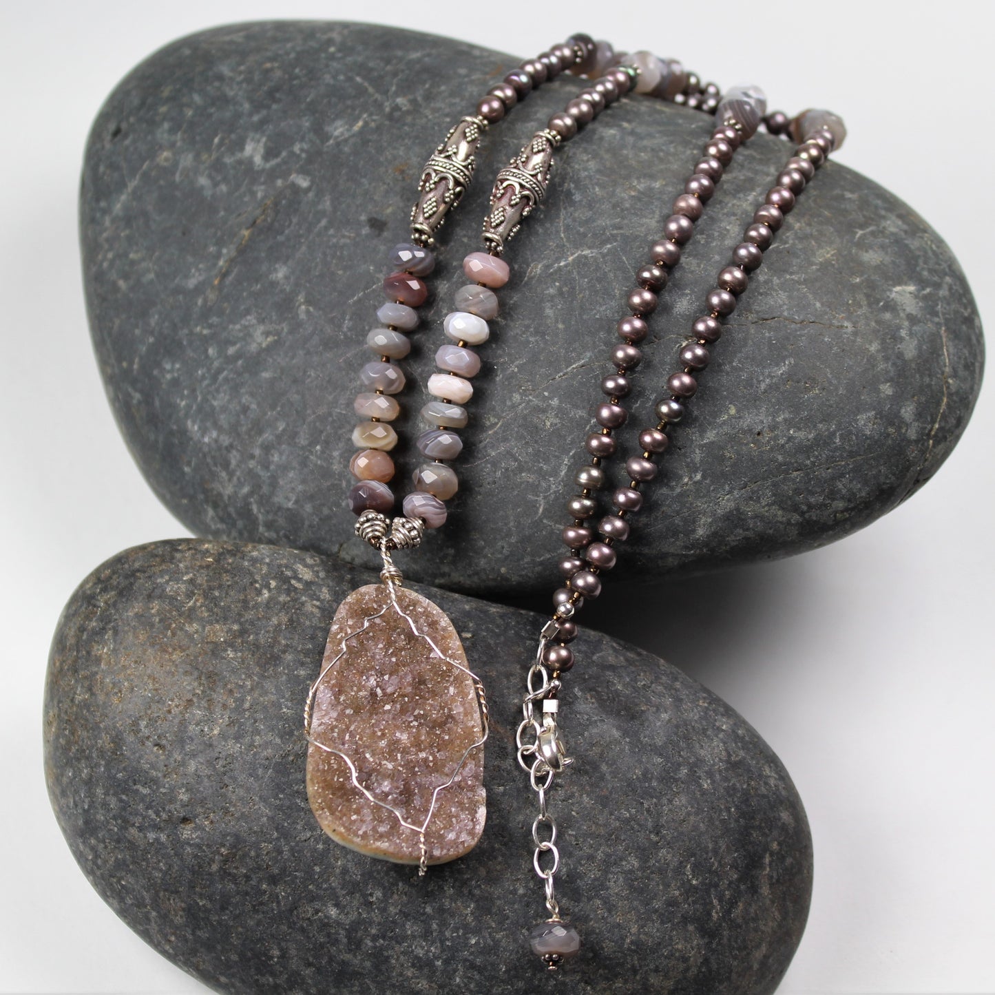 Unique necklace features beige druzy crystal wire wrapped pendant, faceted gemstones and metallic freshwater pearls.