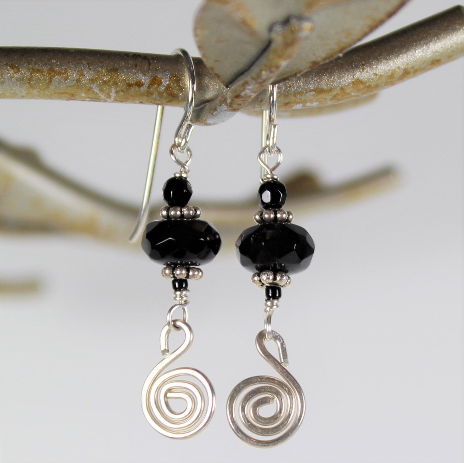 Sterling silver hammered spiral dangles off of gently faceted black onyx on sterling wire earrings