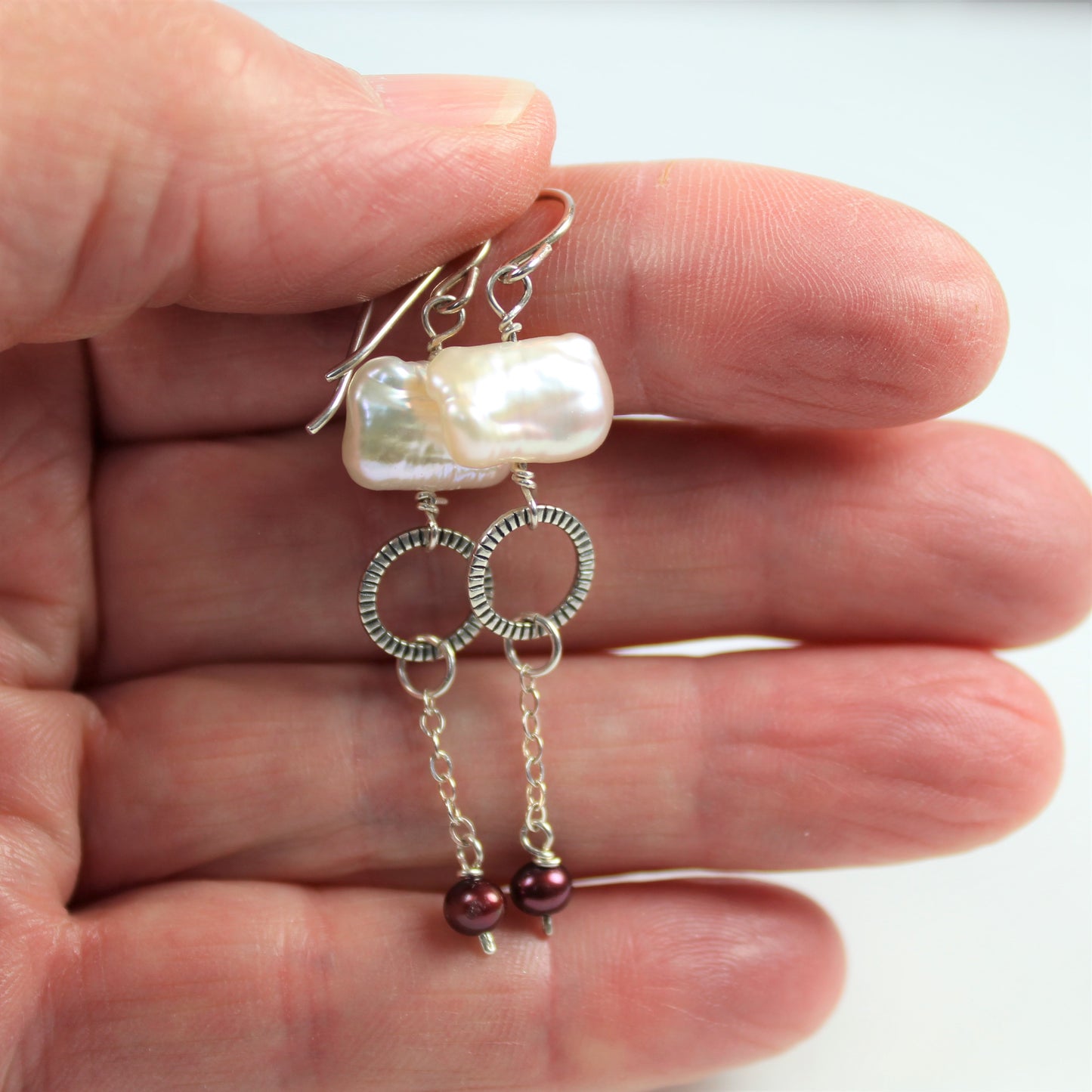 Fashion earrings feature sterling wires, freshwater pearls, sterling oxidized ring and chain