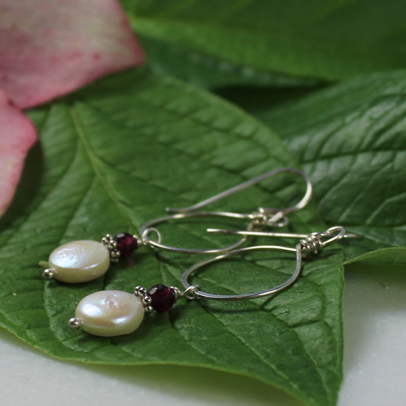 sterling wire earrings feature hammered silver loop and white coin pearl with faceted garnet