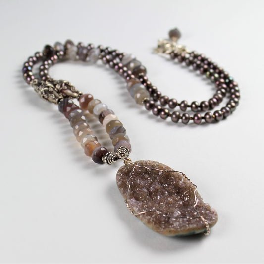 Mauve crystal oval slice hand wrapped in sterling silver wire drops off of faceted botswana agate, mauve metallic pearls and bali sterling silver.