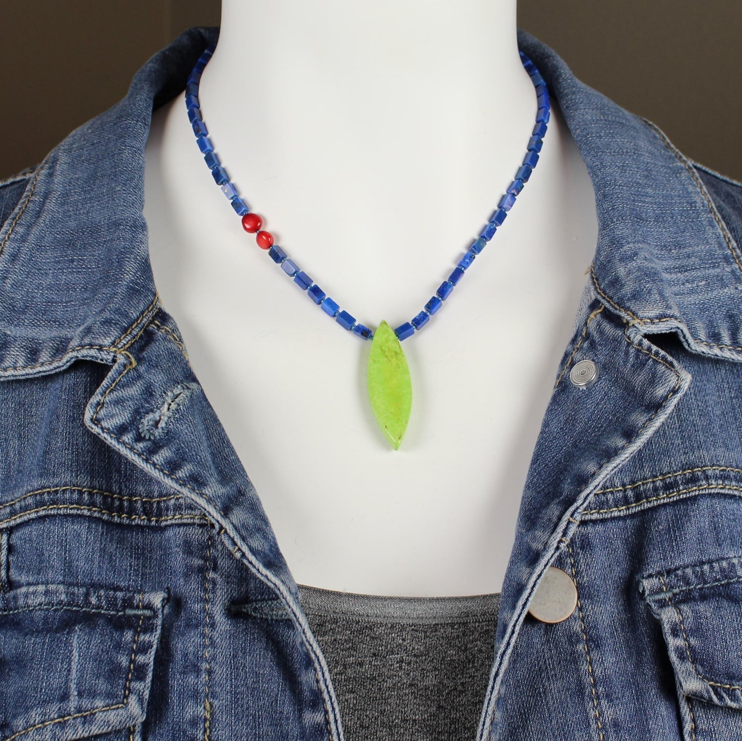 15 inch long asymmetrical necklace of square lapis gemstones and a pointed oval bright lime green stone.